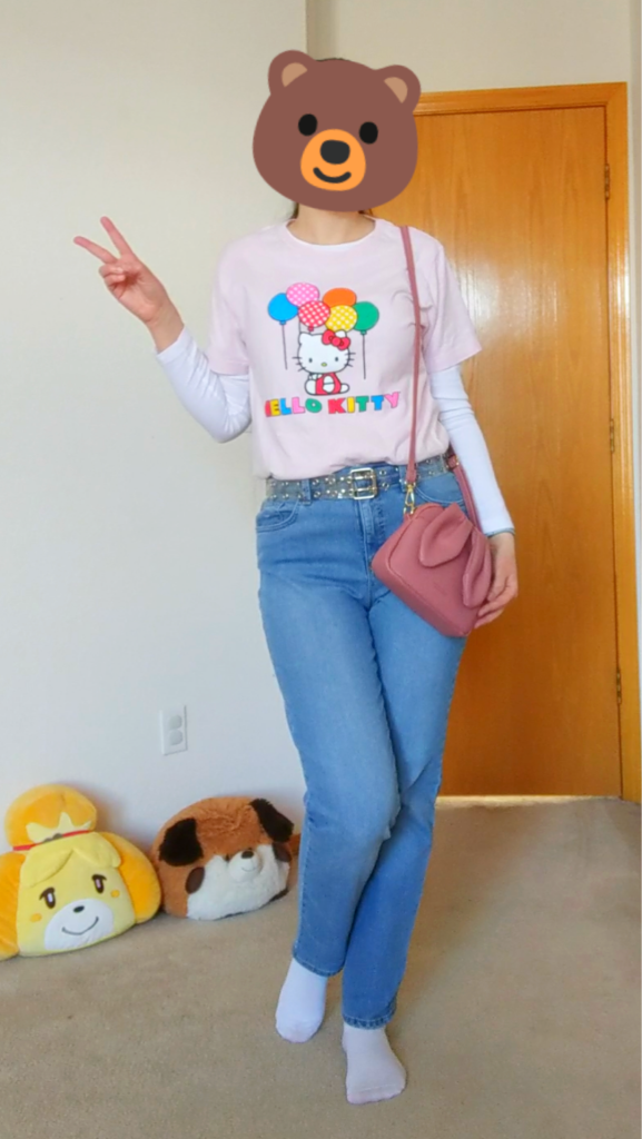 Young woman modeling a Hello Kitty t-shirt with jeans and a clear belt.